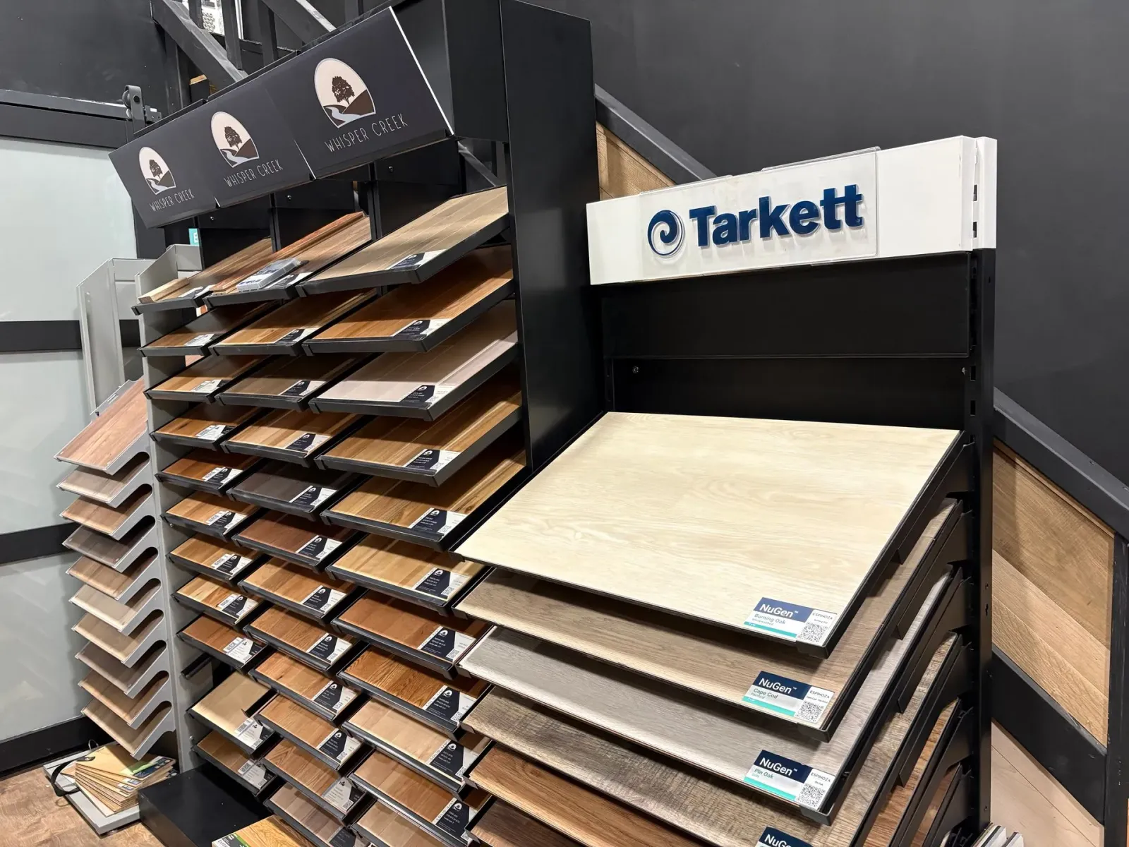 Flooring display racks with Tarkett sample boards in a showroom.