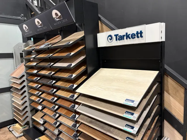 Flooring display racks with Tarkett sample boards in a showroom.