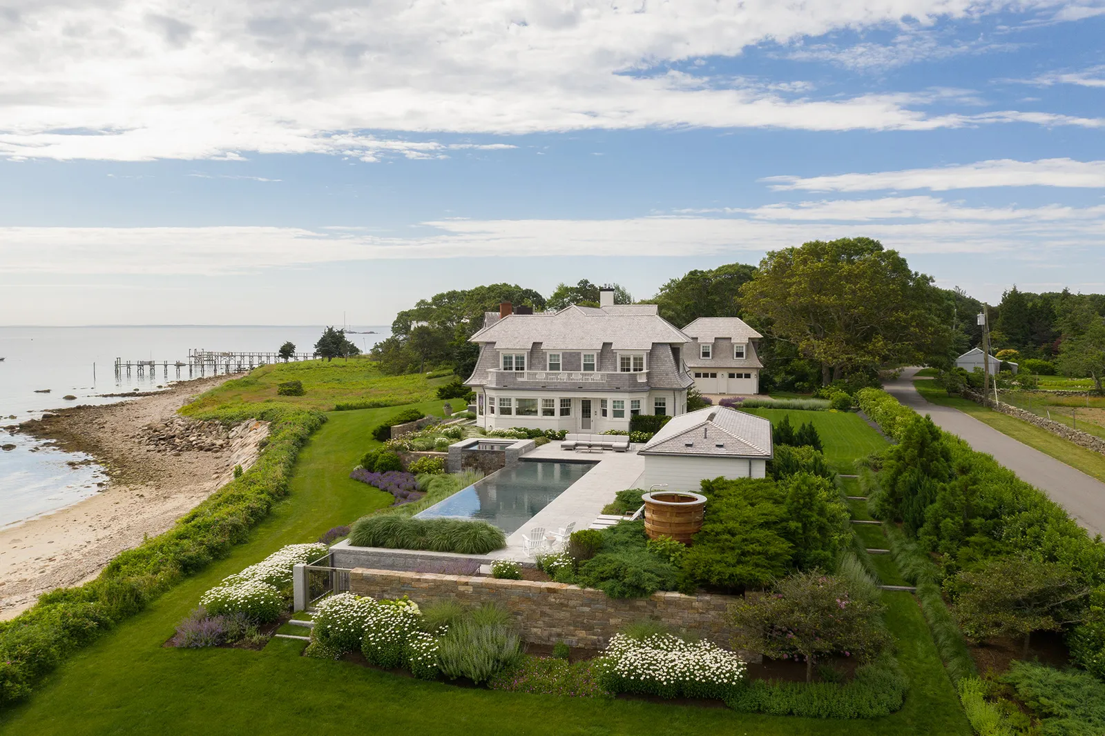 Aerial of a coastal estate with pool, spa and layered garden terraces