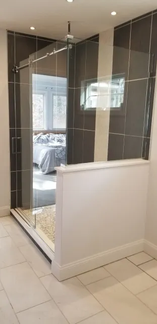 A bathroom with a walk in shower and a large mirror.
