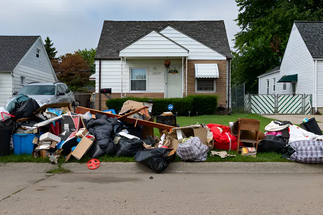 Depiction of a pile of junk on a residential curb.