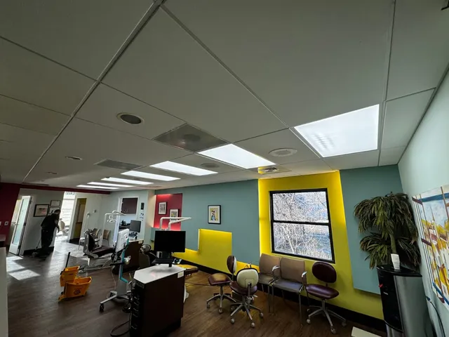 Bright Dental Office with Colorful Walls, Office Chairs, and a Large Window with Natural Light