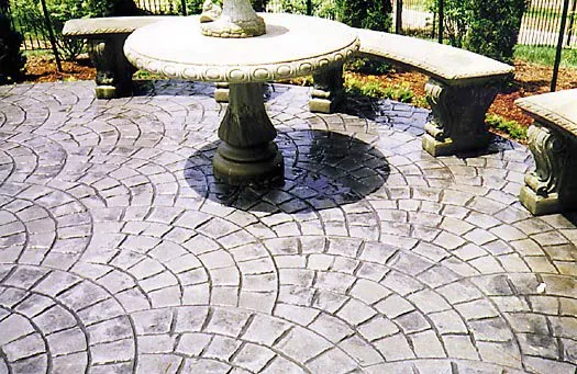 Fan-pattern stamped concrete patio with stone benches