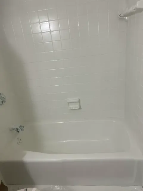 Bathtub and tile surround after reglazing with a clean white finish