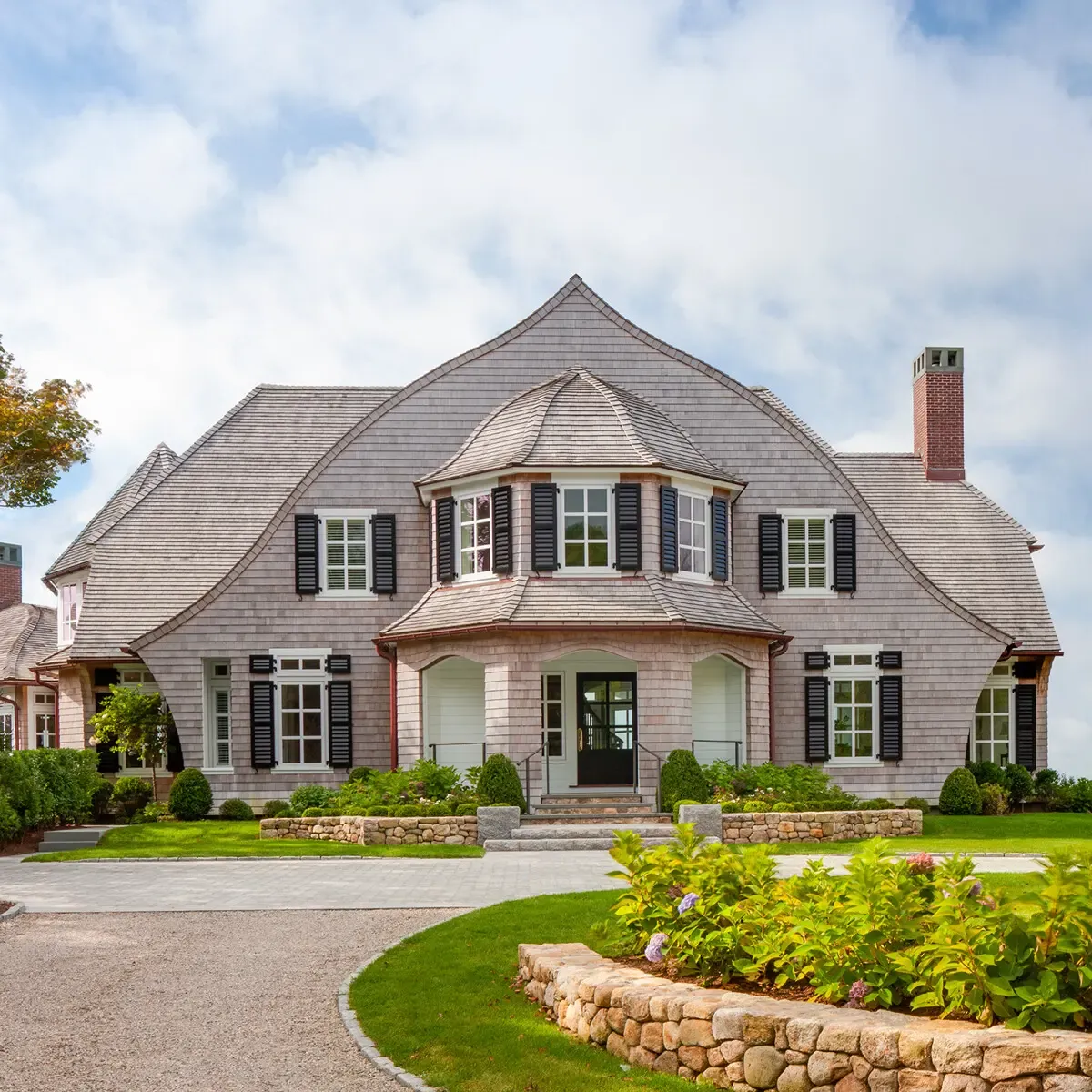 There is enough symmetry to say “grand formal house,” but also enough asymmetry and playful forms and details to say “informal beach house.”
