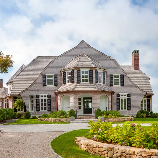 There is enough symmetry to say “grand formal house,” but also enough asymmetry and playful forms and details to say “informal beach house.”
