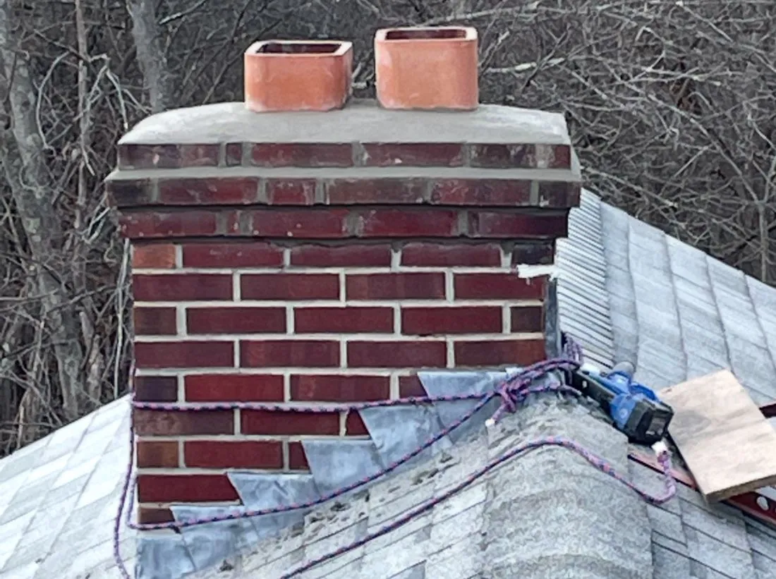 brick chimney being repaired on shingle roof house in MA