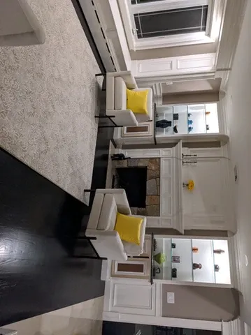 Living room with armchairs, fireplace, and built-in shelves