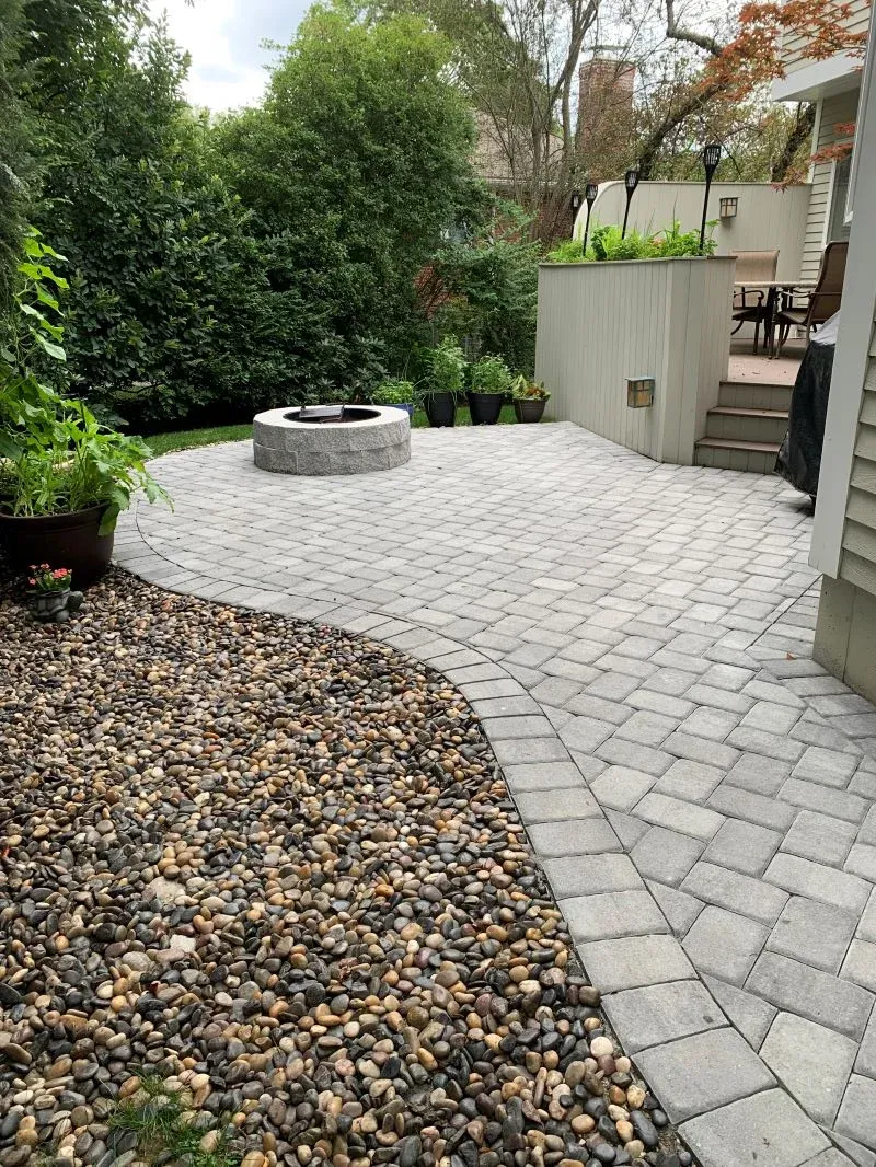 Backyard paver patio with built-in fire pit and decorative stonework in Winchester MA by Goodwood General Construction