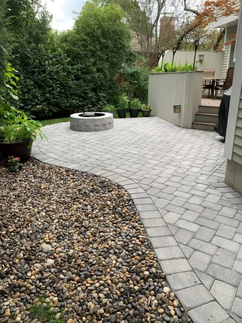 Backyard paver patio with built-in fire pit and decorative stonework in Winchester MA by Goodwood General Construction