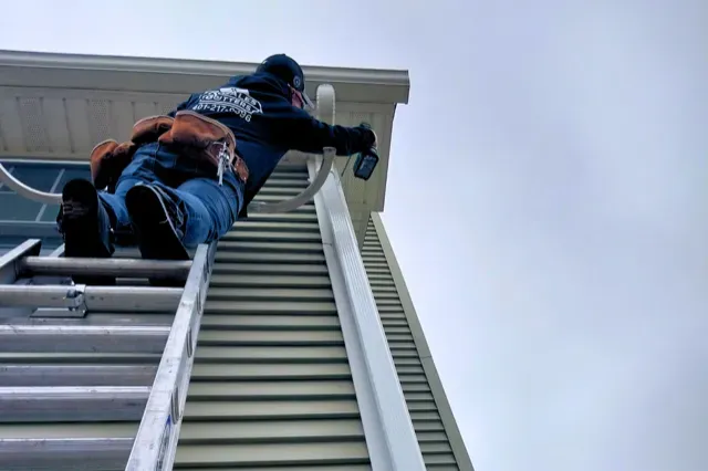 rosales gutters worker installing new a new gutter on a house