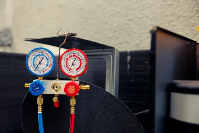 Refrigerant manifold gauges connected to an HVAC unit