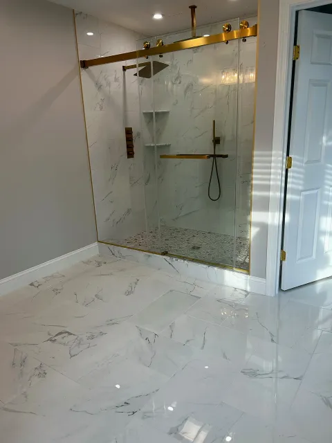 Marble bathroom with glass shower by Adael Construction