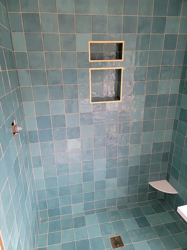Mix of light and dark blue tiles in bathroom shower in Ashland, MA