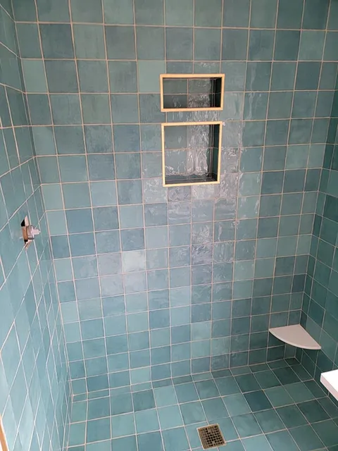 Mix of light and dark blue tiles in bathroom shower in Ashland, MA
