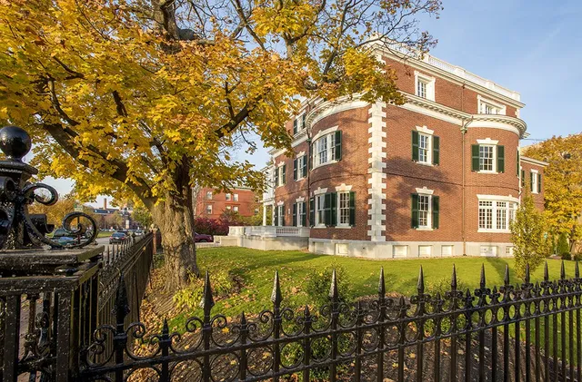 A large brick building with a tree in front of it.