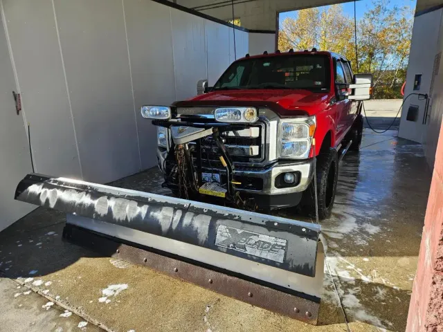 Regan Property Maintenance red pickup fitted with a snow plow, ready for winter in Hudson, NH