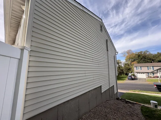 Freshly painted siding and white trim along the side of the home