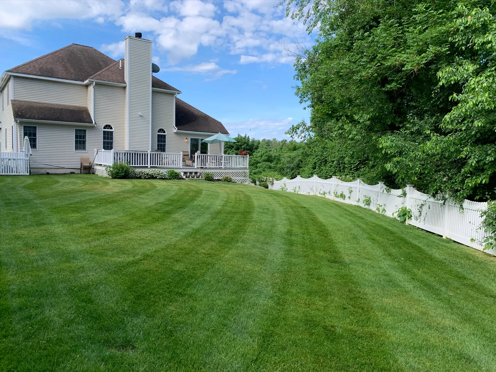 A white house with a lawn in front of it.
