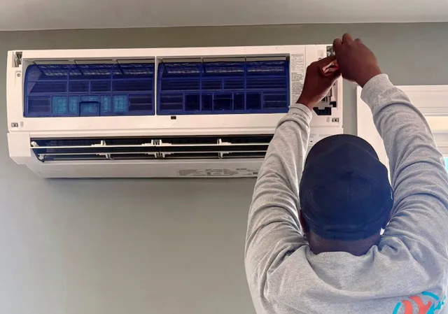 JDK HVAC technician servicing a wall-mounted mini-split