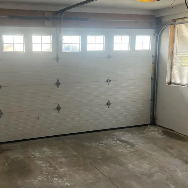 A clean interior of a garage showing the garage door.