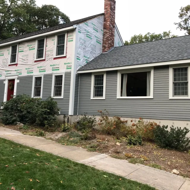 Siding replacement in progress with house wrap