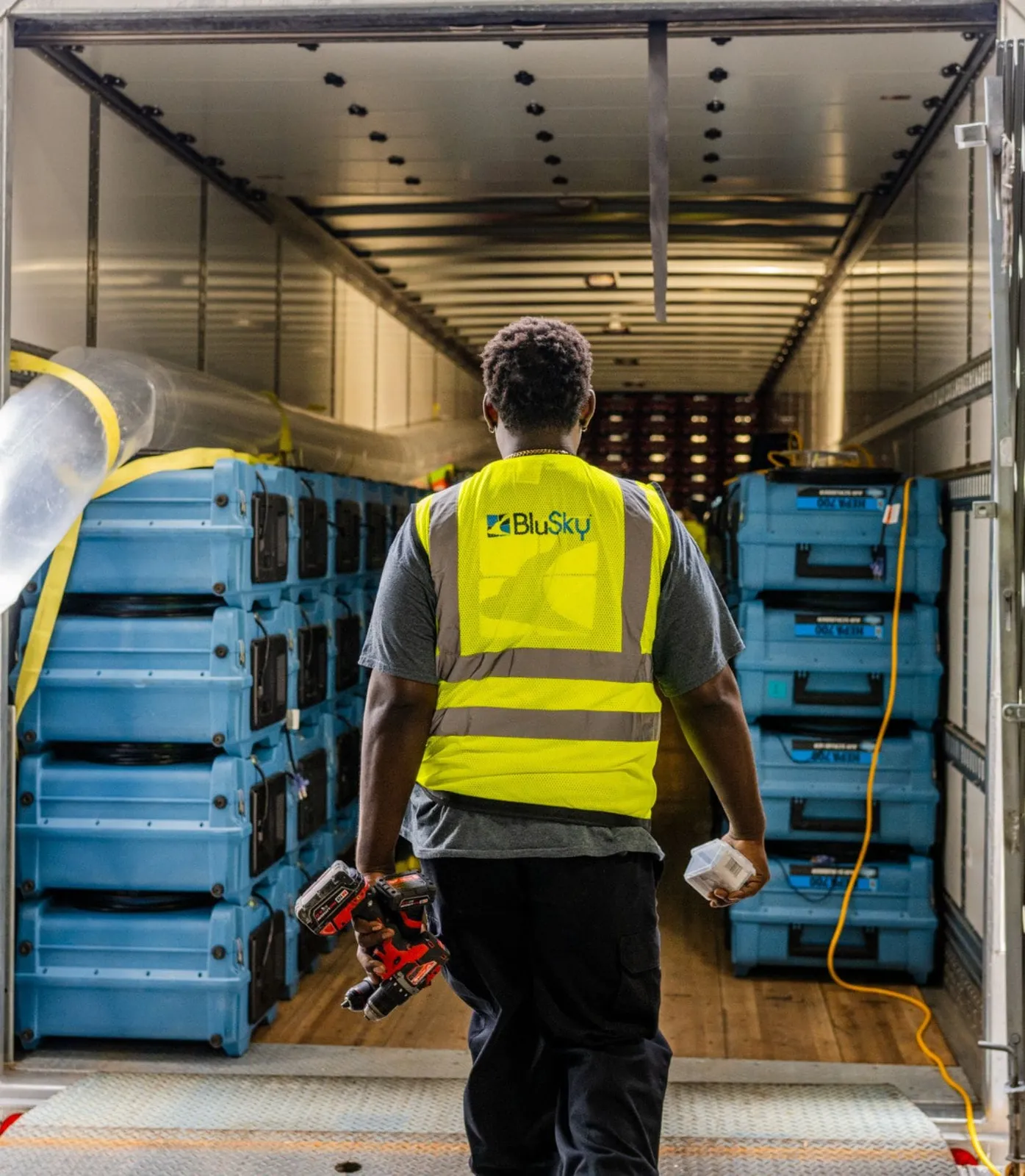 BluSky worker entering restoration facility with restoration equipment