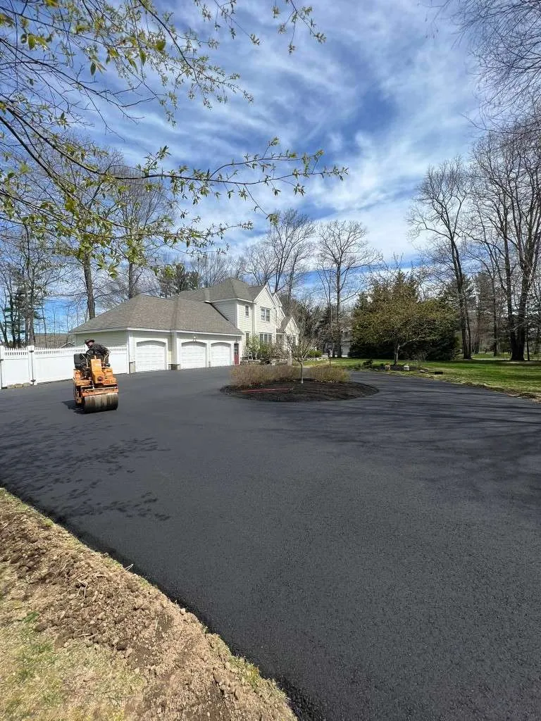 Asphalt paving crew finishing driveway installation