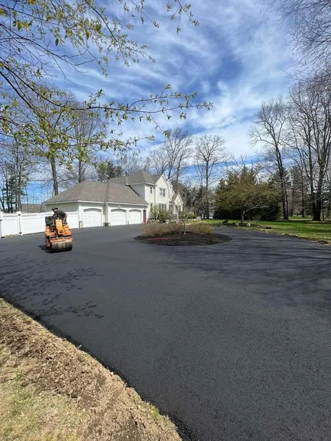 Asphalt paving crew finishing driveway installation