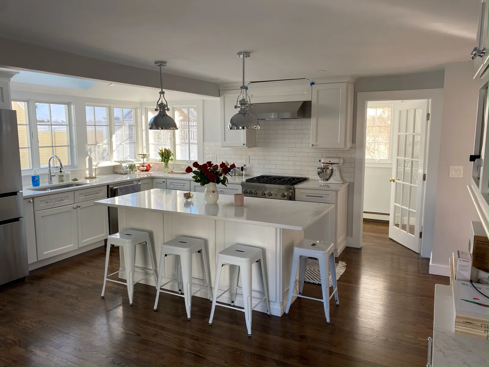 Renovated white kitchen with island and pendant lighting