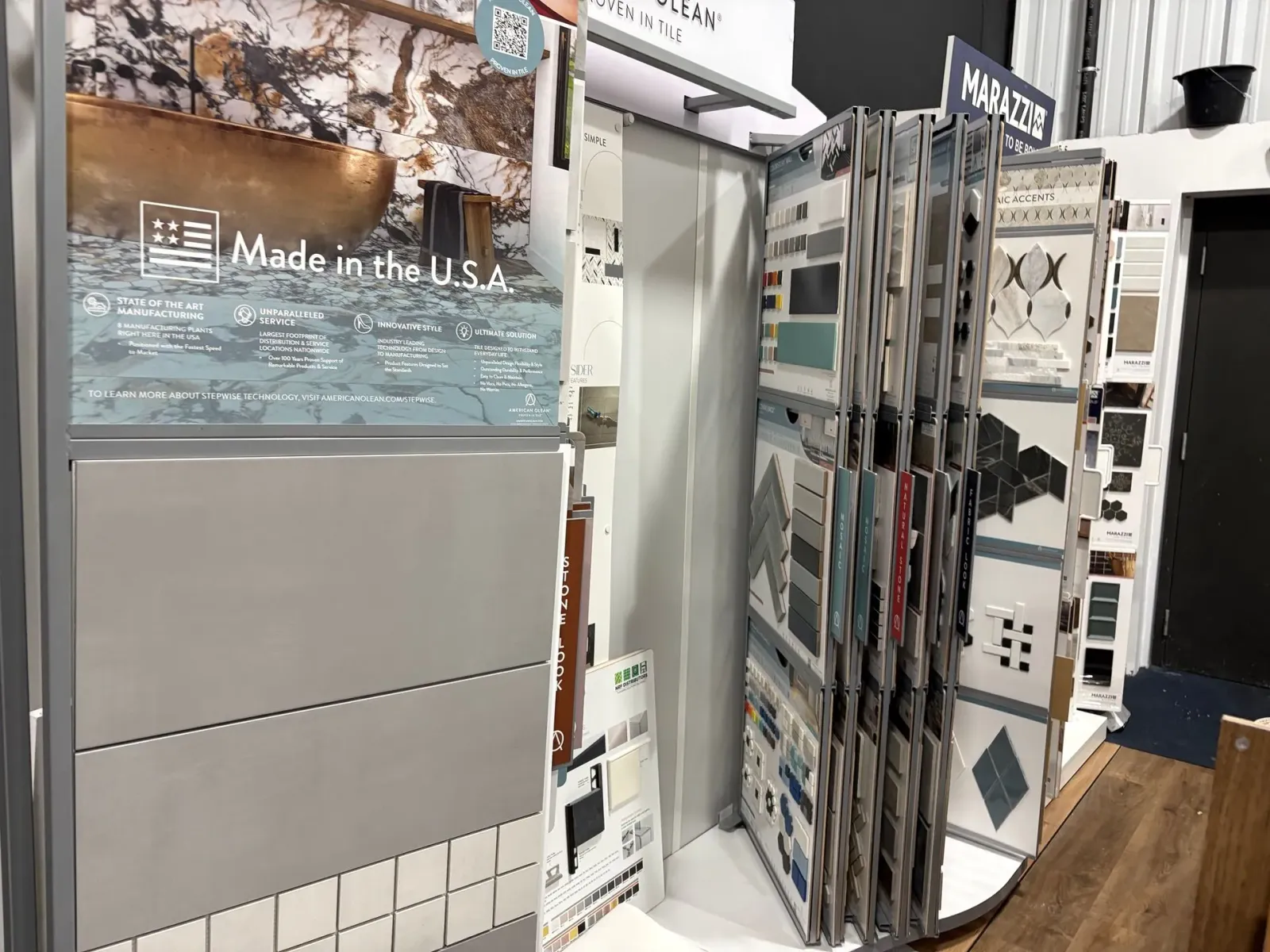 Display booth with glossy mirrored panels and a “Made in the U.S.” sign inside a trade show setting