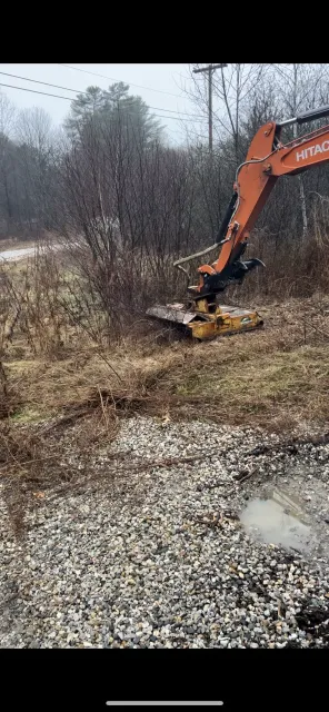 Hitachi excavator clearing brush and vegetation from wooded site with gravel base material