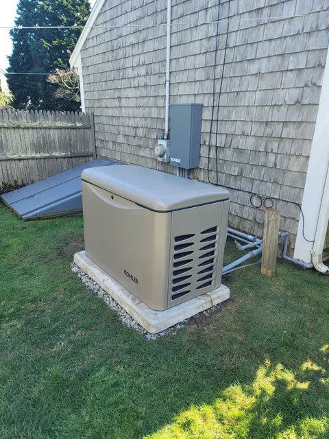 Residential standby generator installation beside a Cape Cod home