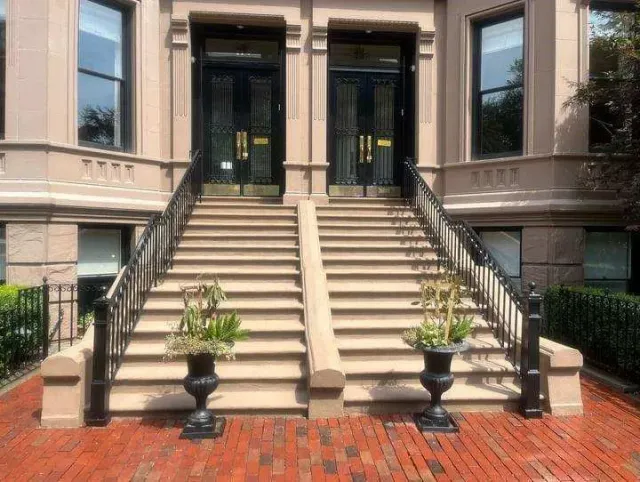 A building with stairs and potted plants in front of it