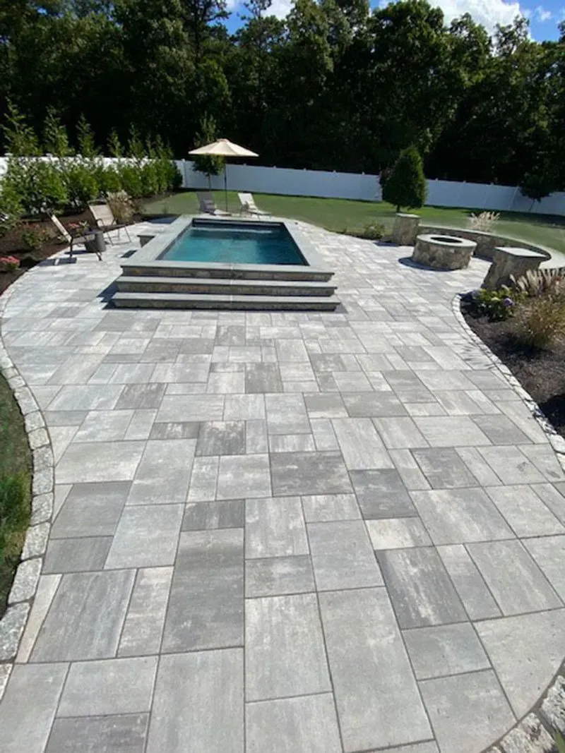 A large patio with a swimming pool in the middle of it