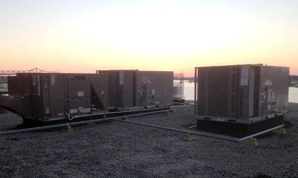Rooftop HVAC units silhouetted at sunset