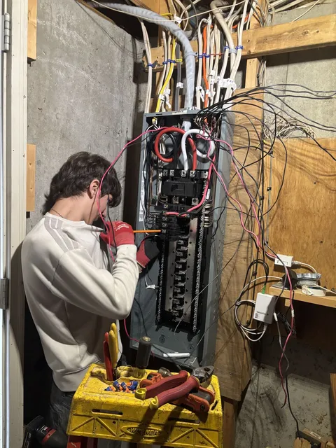A. Pro Electric electrician landing conductors in the new breaker panel during the service upgrade