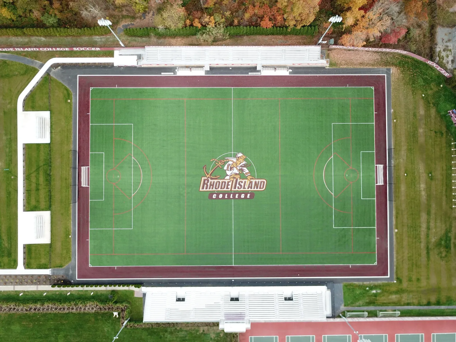 Aerial view of a soccer field at Rhode Island College with a logo in the center featuring a knight mascot and the Rhode Island College name.