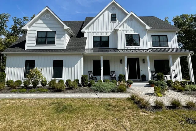 White two-story home with detailed exterior trim and board-and-batten siding — Newtown, CT