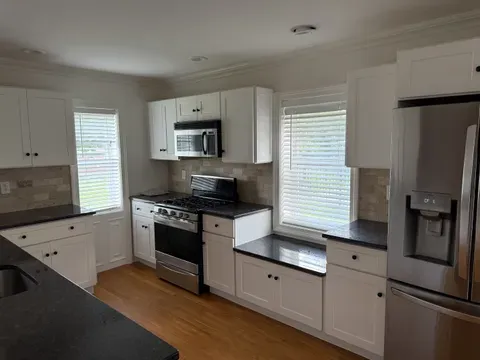 A kitchen after a clean, with a wiped stovetop and mopped floor