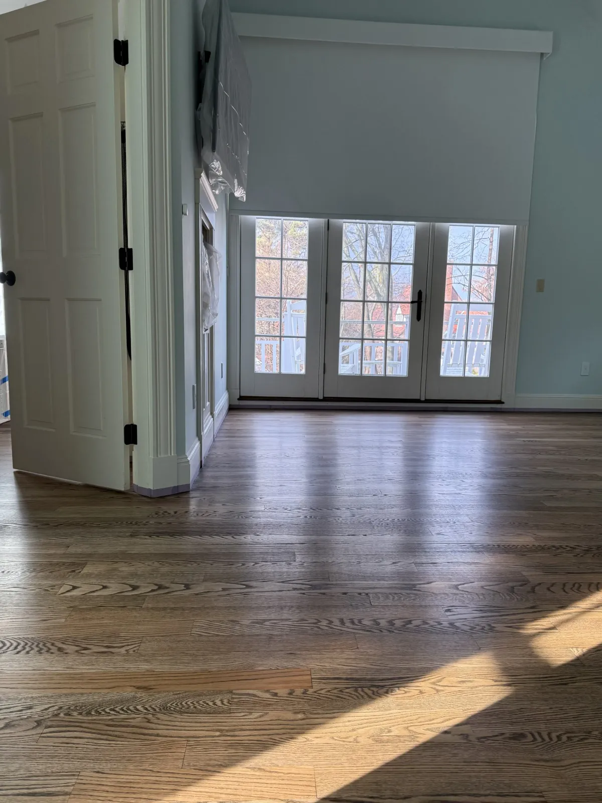 Stained red oak floor by french doors