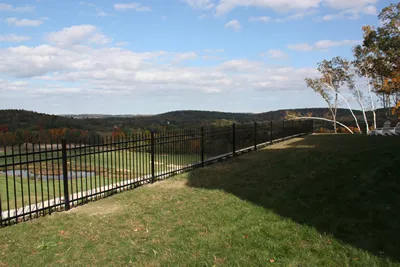 Black ornamental fence across an open hilltop yard