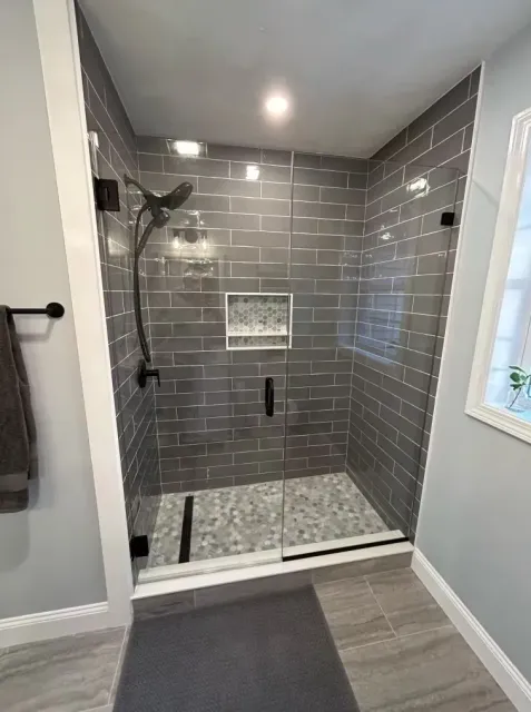 A bathroom with a walk-in shower and a window.