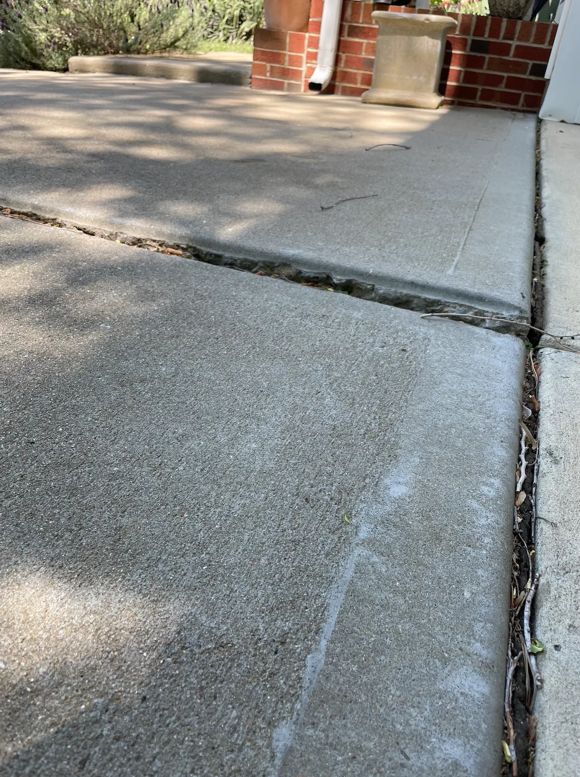 Uneven concrete slab settlement near front porch