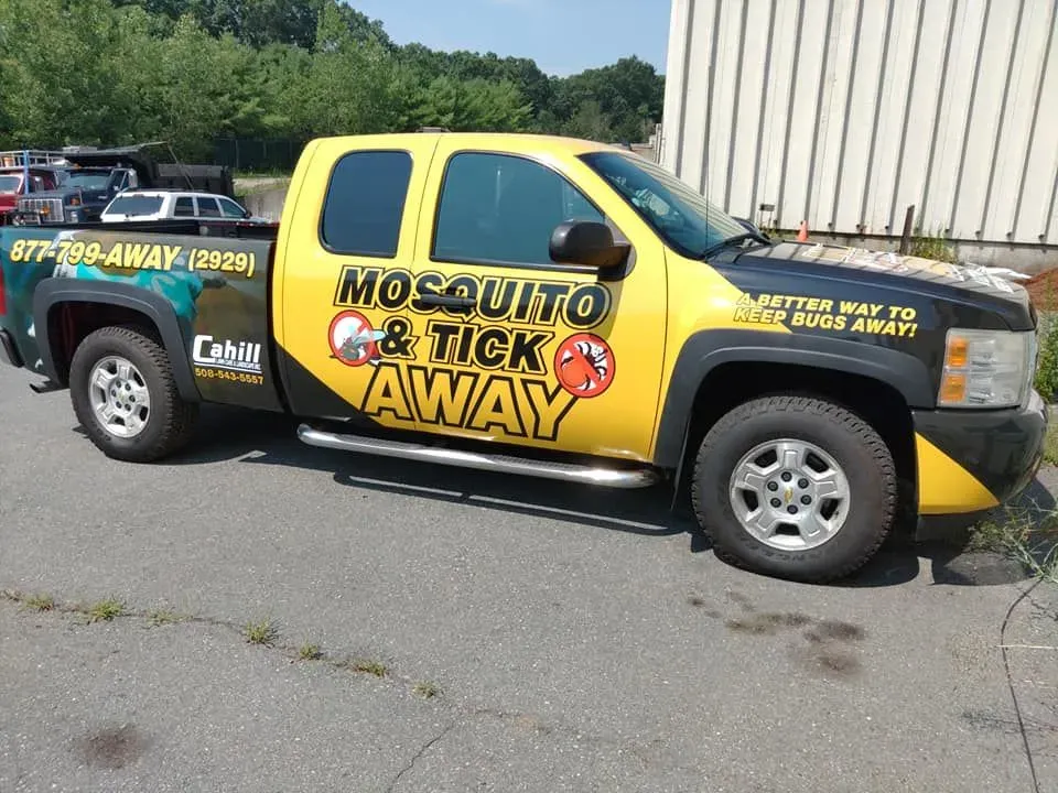 Yellow and black mosquito pest control pickup truck parked outdoors, labeled “Mosquito Be Gone” and “Attack Away.”