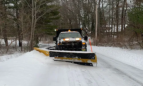 Truck plowing a snowy road