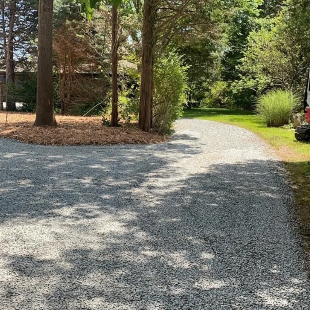 new stone driveway through a wooded property
