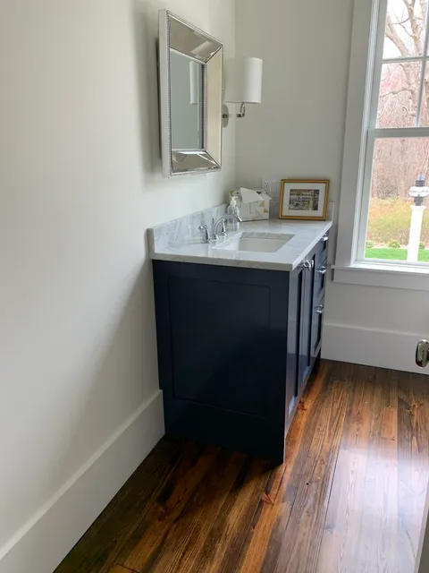 Installed navy vanity with marble top in a finished bath