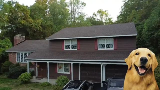 Brown wood-sided home with a new dark asphalt shingle roof and brick chimney