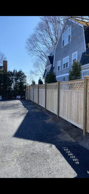 New cedar board fence with lattice topper along a driveway